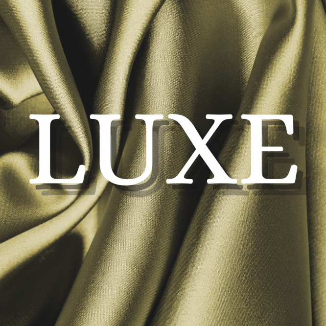 mot LUXE en majuscule sur tissus satiné doré